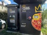 a pizza machine that is next to a parking lot