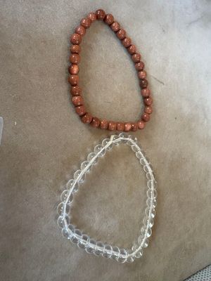 deux lots de perles de verre et un collier de perles posés sur une table
