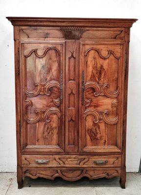 une armoire ancienne en bois, ornée de sculptures sur les portes
