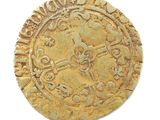 an old gold coin on a white surface with a clock on it