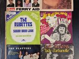 beaucoup de disques posés sur la table, avec des photos dessus