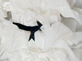 a white dress with a black bow on it in a box