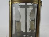 an antique brass hanging lantern with two lamps inside of it