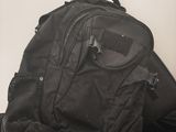 a black backpack sitting on top of a pile of luggage