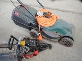 a lawn mower and a chainsaw on the ground