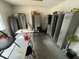 many lockers in a room with a table and chairs