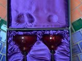 deux verres à vin rouge dans une boîte violette, posés sur un sol carrelé