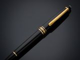a black and gold fountain pen on a dark background