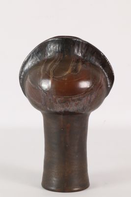a brown vase that has a black handle on it