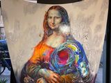 un grand tableau représentant une femme tenant un objet circulaire