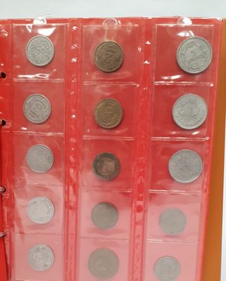 un livre rouge contenant un tas de pièces de monnaie