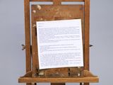 a wooden easer with a piece of paper on top of it