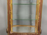 une vitrine ancienne avec des étagères en verre et des finitions dorées