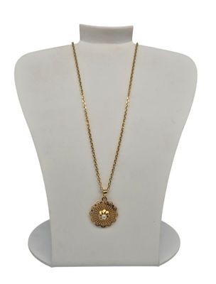 un collier en or avec un pendentif en forme de fleur sur un mannequin