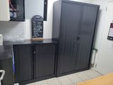 a black cabinet in a kitchen with a chalk board on top of it