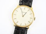gros plan d'une montre sur une surface blanche avec un bracelet noir