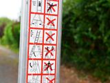 a sticker on the side of a pole that has a lot of signs on it