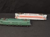 two toy trains sitting side by side on a black surface