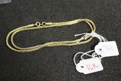 deux étiquettes accrochées à une chaîne en or sur un fond noir