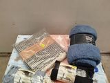 un tas d'objets posés sur un lit, avec un chapeau dessus