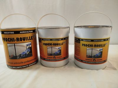 trois seaux de peinture posés sur une table blanche