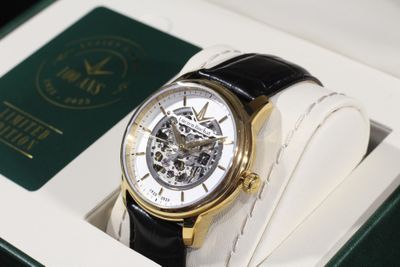 une montre noire et dorée dans un coffret blanc