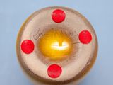 a close up of a glass object with red dots on it