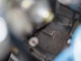 a close up of a motorcycle engine with a blue handlebar