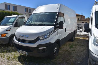 une camionnette blanche garée à côté d'autres camionnettes sur un parking
