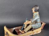 a figurine of a man sitting in a boat