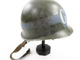 an old helmet with a blue stripe on it sitting on top of a wooden stand