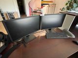 two computer monitors sitting on a desk with a keyboard and mouse
