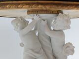 a statue of two cherenshes holding a gold plate