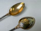 two spoons that are sitting next to each other on a table