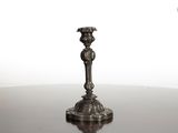 une bougie posée sur une table, sur fond blanc