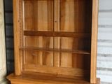 une armoire en bois surmontée d'une étagère à livres