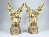 Deux statues d'anges ailés sont posées sur un socle