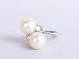an image of a pearl and diamond ring on a white surface