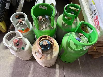 de nombreuses bouteilles de gaz posées les unes à côté des autres sur le sol