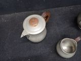 two cups and a teapot sitting on the floor
