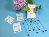 some pins and flowers in a vase on a blue table