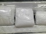 four bags of mattresses in a store display case