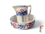 a white pitcher and a bowl with a blue and red design on it