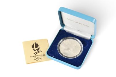 une pièce d'argent olympique dans un coffret bleu contenant une médaille d'or