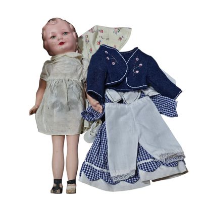 a doll that is standing next to a doll that is wearing a dress