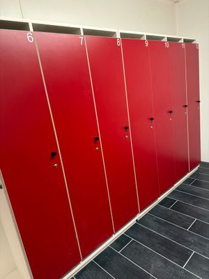 une rangée de casiers rouges dans des toilettes publiques