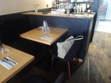 tables and chairs in a restaurant with a bar in the background