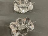 four clear glass vases on a table with a black table cloth