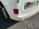 une petite voiture blanche garée sur le bord de la route