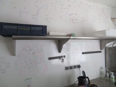 un tableau blanc accroché au mur au-dessus du plan de travail de la cuisine
